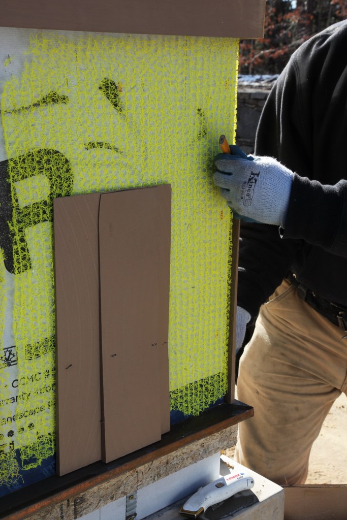 The bottom course of shingle is two layers: a starter course and the first visible course of shingles. For the first corner shingle on the starter course, draw a line on the back side leaving plenty of room for the rainscreen.