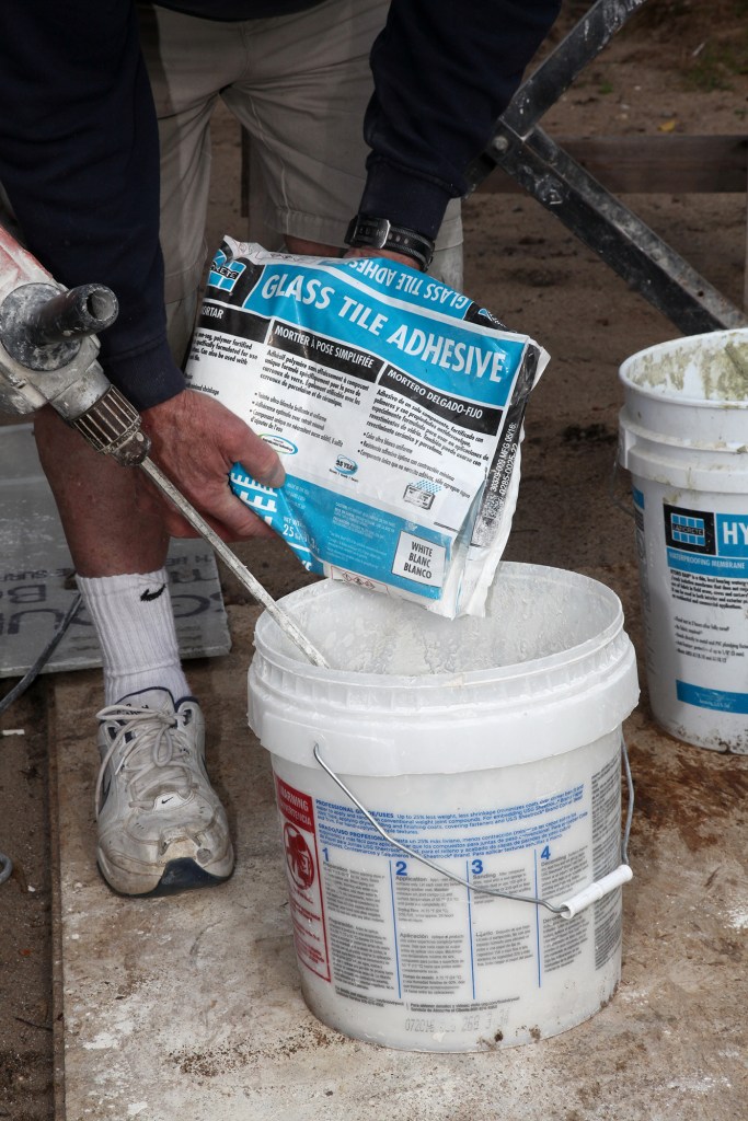 Certain types of tile, such as glass tile, may require thinset that’s designed specifically for that tile. Here, the bag of adhesive is clearly labeled for its purpose.