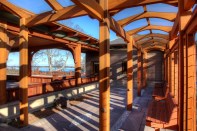 On a Craftsman-style home on Cape Cod, arched, red-cedar cross beams support a glass covering for this arbor.