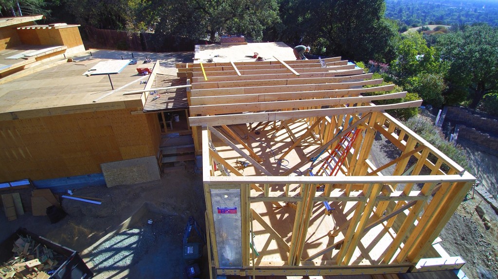 Custom-ripped LVL rafters create a slope toward the gutter from both the center and the edge of the roof.