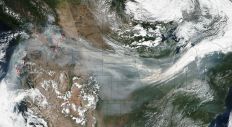 A NASA satellite captured this image of smoke traveling across the country on September 4, 2017. The actively burning areas are outlined in red.