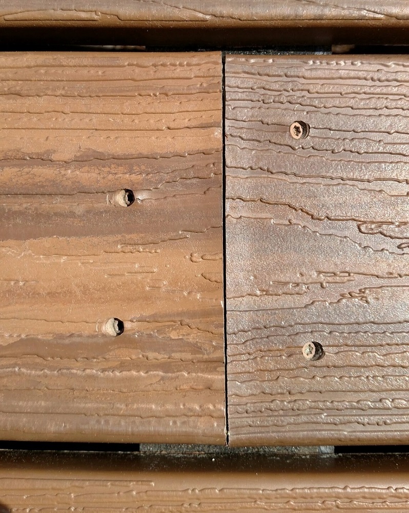 The cut ends of composite decking will absorb moisture and can swell, as shown here. Sealing the end cuts with lumber wax will help prevent swelling.