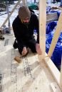 Carpenter Matt Friel taps a dovetail tenoned stud into place in the wall plate mortise.