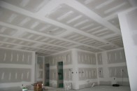 Here's the goal. The most common level of drywall finish is Level 4, shown here, in which seams and corners have been taped, then coated (along with fasteners) with two coats of joint compound, and sanded with a fine-grit paper to remove imperfections. If the room will be painted with anything other than a flat paint, the author recommends a Level 5 finish, which includes a skim coat of joint compound applied over the entire surface.