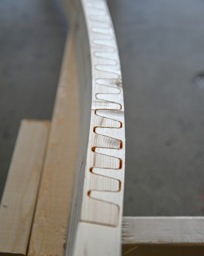The "valleys" of the  unique tooth pattern are flexible enough to bend and twist. Once clamped and glued, the bent board maintains structural integrity.