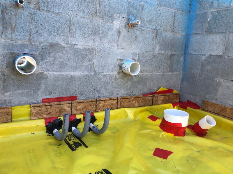 Stego Mastic (black goop around penetrations) and Stego Tape (red) prove effective for sealing Stego Wrap—a thick, polyolefin plastic specifically designed as a subslab vapor retarder.