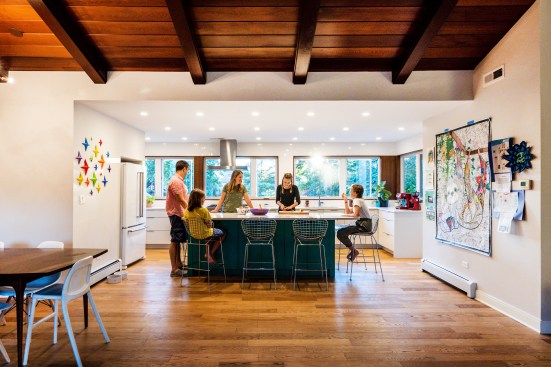 Here, too, fewer upper cabinets provide space for more windows and ample wall space. Again white is used to contrast to the darker wood ceiling and floor. Lots of wall space  splashed with color, textrue and family artwork provides a personalized touch.