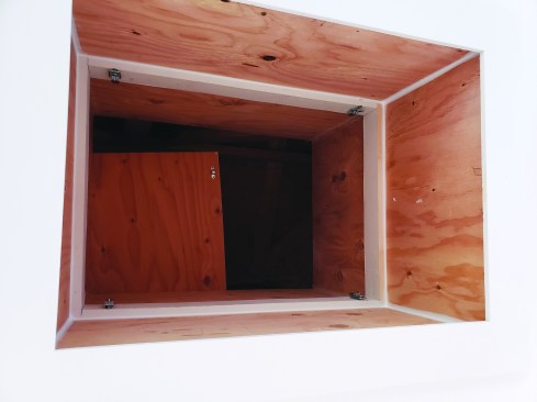 Viewed from below with the ceiling panel removed, the walls of the access extend far enough up to retain the blown-ininsulation.