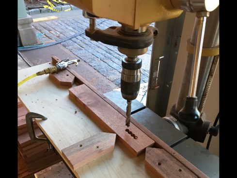 We cut the perforations, starting with a rough hole on the drill press. I manned the press, using a simple jig with re-locatable end stops and a 7/16” spur bit to bore four adjacent holes (nearly 2300 holes in all).