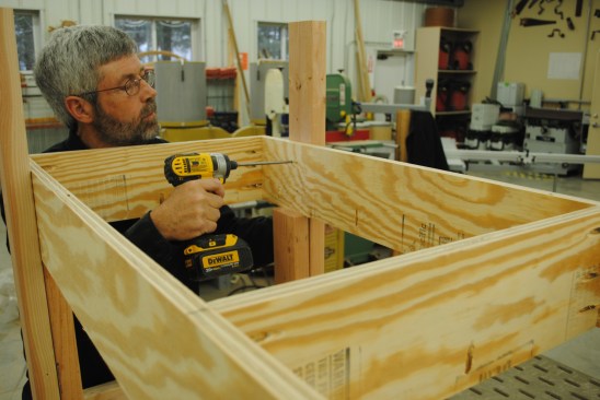 Position the shelf frame on spacers and screw it to the legs.