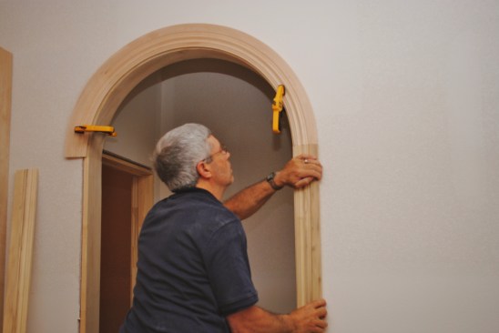 After cutting the circle arch, clamp it back in place and make the cuts on the side jambs. Those cuts should be square to the trim (parallel to the floor).
