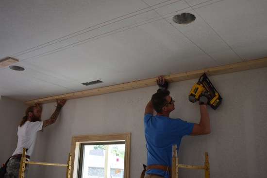 Around the perimeter of the room a 2x6 attaches to the ceiling as a nailer for the 5 1/2-inch wide preimeter beam.