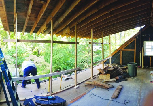After raising the roof into position, the crew removed the bottom sections of the existing rafters.