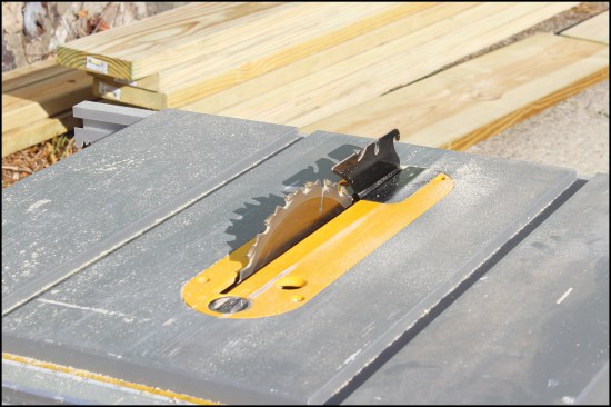 A riving knife, aligned in the path of cut, holds the saw kerf open beyond the blade, helping to prevent pinching and kickback.