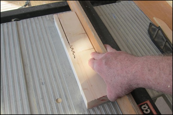 A sacrificial fence face allows it to be set flush alongside the blade for close and narrow cutting. The author hooks two fingers over the fence as a safety control, a consideration in determining its height.