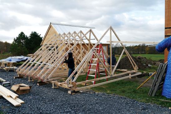 Then we set the remaining trusses using Simpson's Spacer Bracers (strongtie.com) at three points along the top chord . We aligned the end of each bottom chord 8 inches from the snapped line on the uphill timbers.
