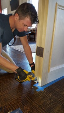 After aligning the door panels, screws anchor the bottom free corners in their adjusted positions.