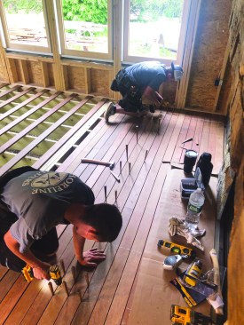 Wedges straighten the infill boards and keep the gaps consistent while a crew member tacks those boards in place.