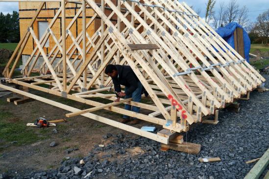 We checked for plumb and verified the on-center layout, then nailed on the lateral bracing required by the truss manufacturer (5).Down the middle, I nailed two 2x6 catwalks to facilitate blowing in loose-fill insulation. We also stiffened the assembly by nailing on 2x6s 2 feet in and parallel to the ends of the trusses.