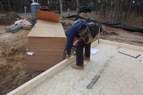 The first things the layout crew marks on the plates are the openings. Here the crew member measures to the middle of the wall, which is  the middle of a center window.