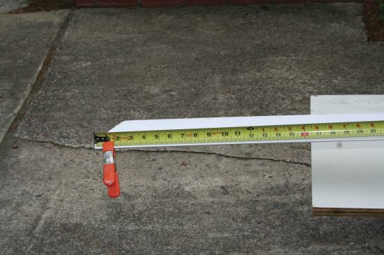 Transferring measurements to a floppy piece of molding can be challenging, especially when measuring from an end that’s cut at an angle. When measuring from the long point, I hold the tape in place with a spring clamp.