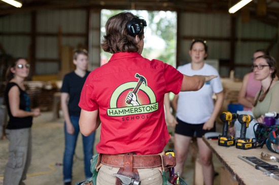 Maria Klemperer-Johnson, founder of Hammerstone School, addresses a class in the shop at the school.