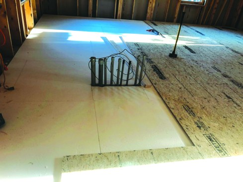 The first layer of subflooring was installed perpendicular to the foam, with the seams between the OSB sheets staggered above the seams in the foam.
