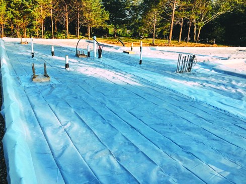 To help control moisture, the crew put down a layer of 10-mil polyethylene sheeting—which also acted as part of the air barrier—over the crushed stone.