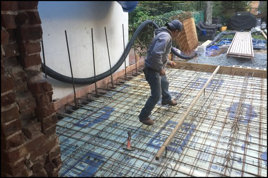 The architect’s initial structural design called for a crawlspace under a framed first floor supported by block frost walls, but the city’s zoning administrator required slab-on-grade construction. The resulting structural redesign called for a robust 6-inch-thick slab reinforced with two layers of heavy-duty welded wire mesh. The slab tied into the 12-inch-thick-block frost walls with #5 L-shaped rebar placed 12 inches on-center. Two-inch XPS rigid foam was placed over the crushed-stone base; the foam’s seams were taped. 
