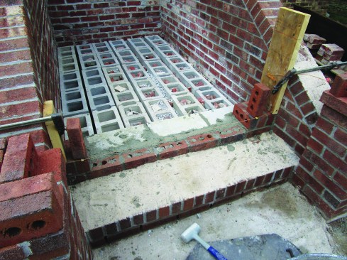 The twigs held the line even with the upper corners of the starter bricks to guide placement of the rest of the rowlock course across the step.