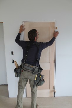 When the margin between the door slab and head jamb is perfectly even across the top, drive additional nails to hold the bottom of the hinge jamb in place.