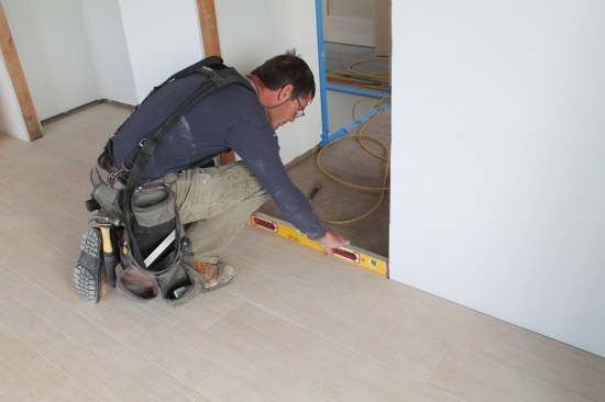 Check the level of the floor within the opening and note any discrepancies, which will be addressed when the jamb legs are cut.