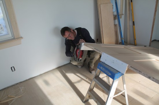 Keeping the double doors temporarily secured in the jamb, elevate the bottom to cut the jambs to length.