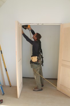 To install the double-door unit, start by driving a single nail through the jamb at each of the four corners.