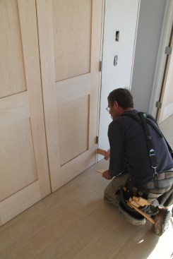 Shim the side jambs until the gaps between the slabs and along the top are perfectly even. The top corners of the door should align perfectly as well.