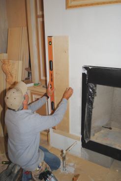 A board is screwed to the wall beside the firebox for attaching the pilaster.