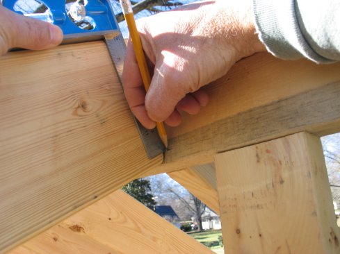 At the top of the rafter, slide the square up to the ridge and mark where the blade touches.