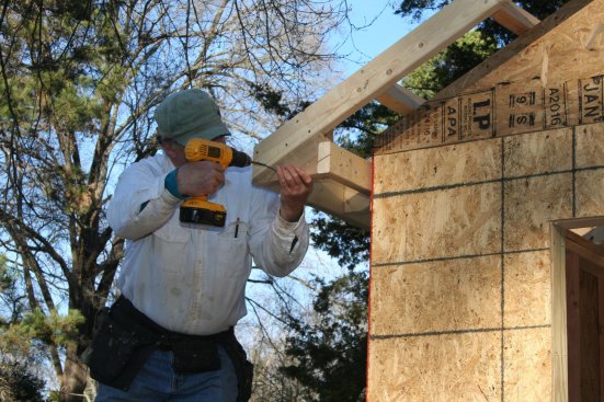 The block provides attachment for  the triangular piece that fills in the end of the return. The face stays in plane with the barge rafter and the bottom edge lines up with the blocking for the soffit.