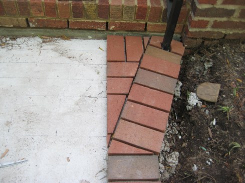 The cut brick then takes its place as the final piece in the flare border. Other bricks receive straight angle cuts to square off the rest of the flared section to the field tile.