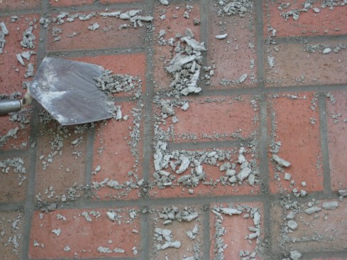 Once the mortar has set up over night, the excess is scraped off the surface. 