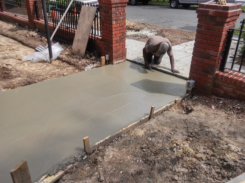 After the concrete is placed, a mag float smooths the surface of the slab. An absolutely smooth and flat slab is not necessary as a substrate for the bricks. 