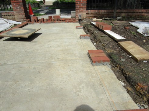 Mason’s twine stretches the length of the walkway to guide brick placement. To keep the bricks following a perfectly straight line, the author installs them at precisely measured and laid-out intervals along the edge. 