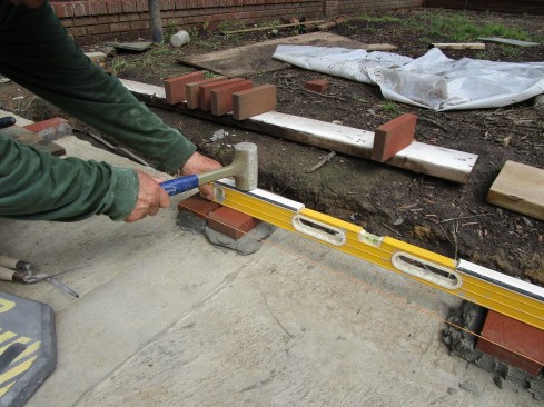 The installation leapfrogs in the opposite direction with the author adding a brick next to the one he just leveled to.