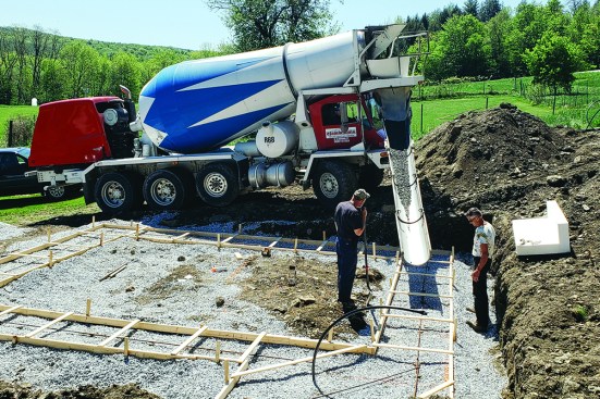 After the crew stakes the forms in place, a concrete truck carefully fills them.