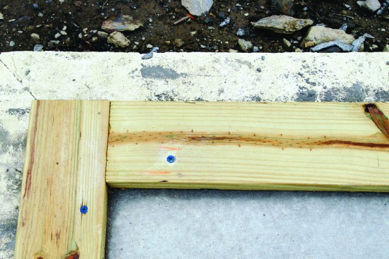 The treated sills for the walls attach to the slab with concrete screws for positioning. Embedded J-bolts around the perimeter of the slab provide
permanent anchoring for the framing.