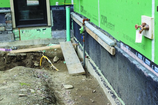 Where they hadn’t begun the veneer process, the crew installs temporary cleats to install the cap, which sits on top of the lath-covered rigid foam.