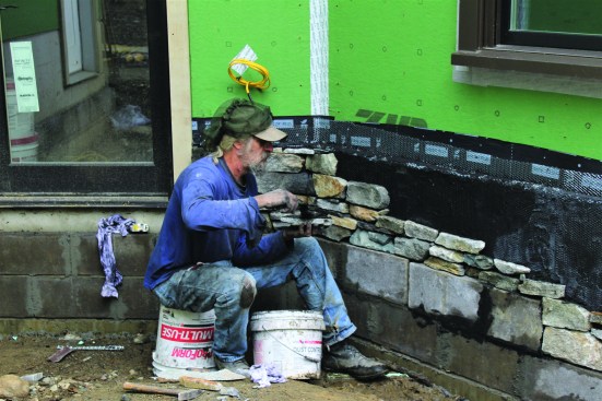 The crew uses the same process to apply stone to the scratch-coated areas.