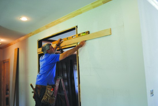 In preparation for mounting the track for the barn-style doors, the author drew a level line across the opening and onto the walls at the appropriate height.