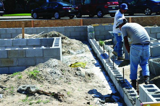 After letting the beams cure, the masons build short foundation walls. Lengthsof rebar are drilled and epoxied to tie the block to the grade beams, and the concrete block is then fully grouted.