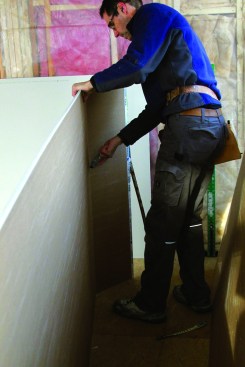 Hold the square in place with one foot. Snap the piece back and cut through from the opposite side.